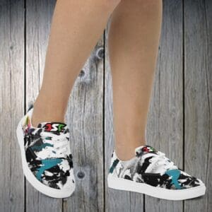 A person wearing white shoes with black and blue flowers.