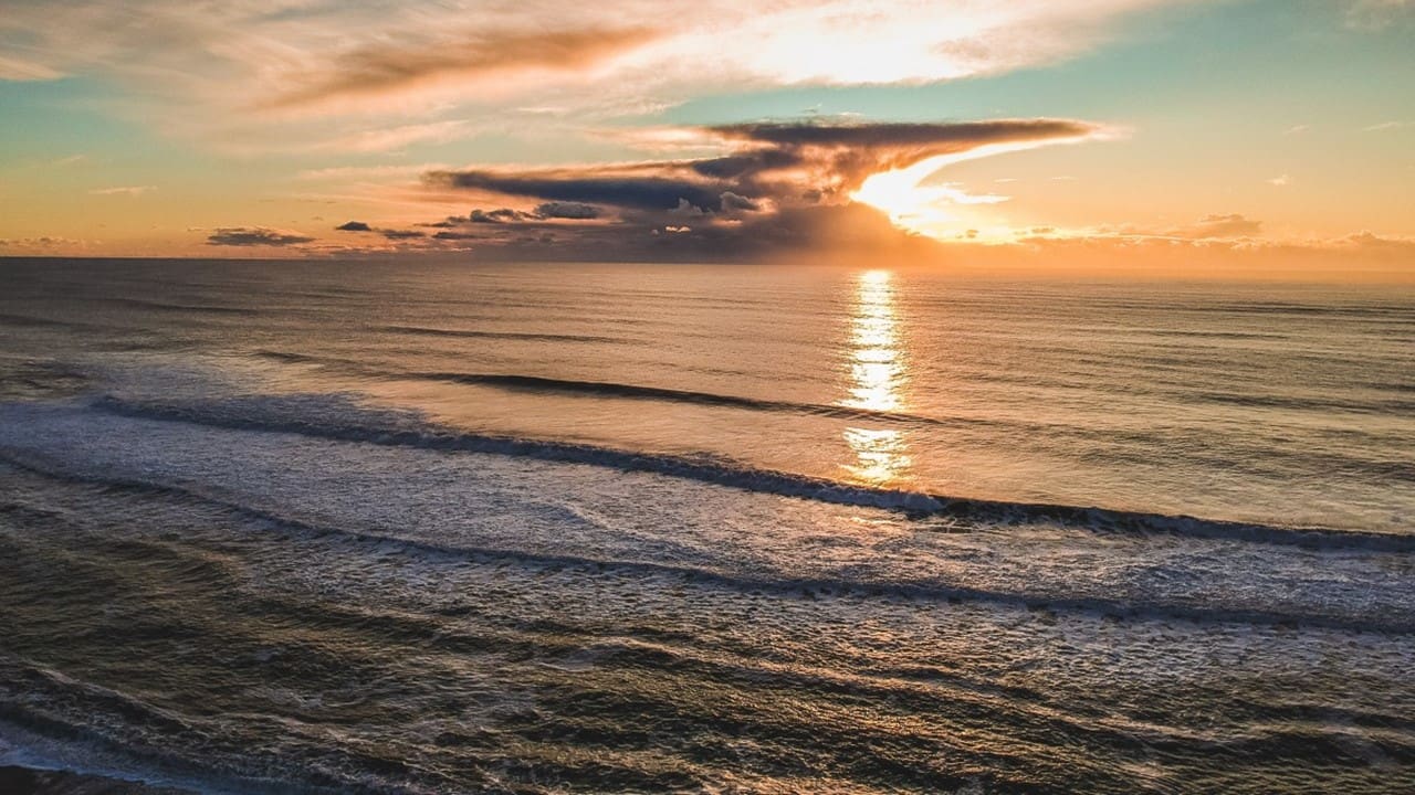 Golden sunset over ocean with gentle waves