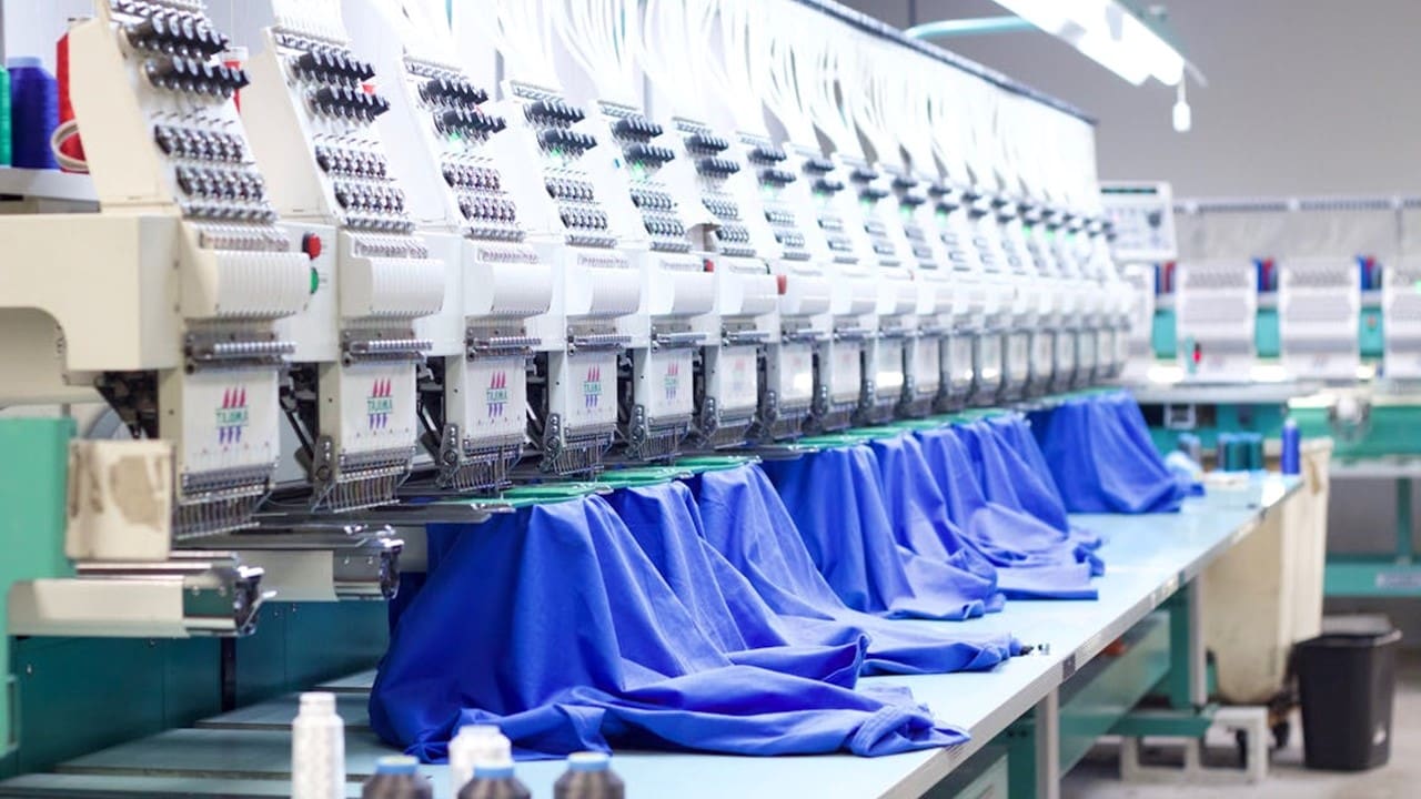 Industrial embroidery machine stitching blue fabric